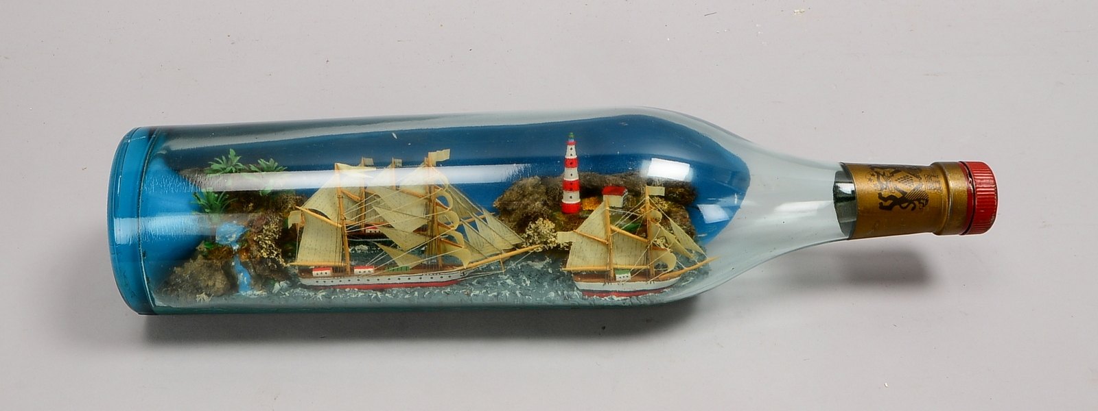 Buddelschiff, Drei Segler vor Küste mit Leuchtturm; Länge Glasflasche 50 cm