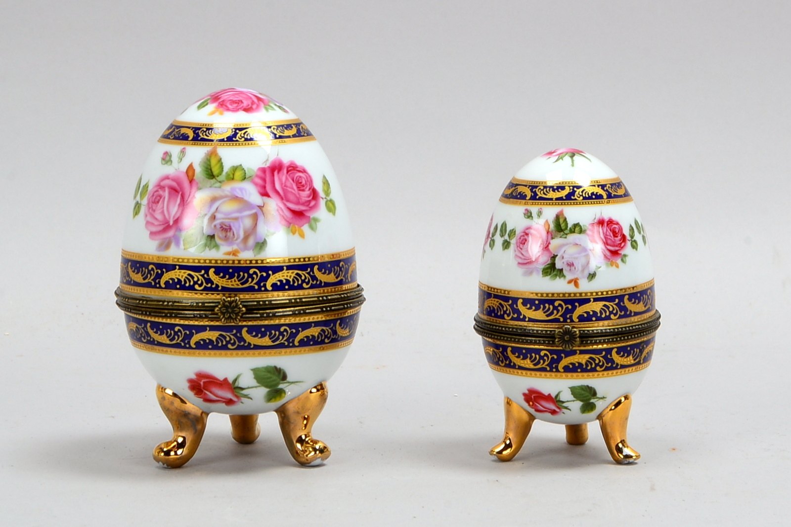 Limoges/France, 2 Sammler-Porzellaneier, jeweils mit Handbemalung - dekorgleich; 1x Höhe 9,5 cm, und