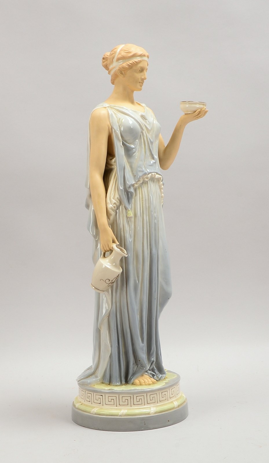 Royal Dux, Porzellanfigur, 'Griechin mit Krug und Schale', Figur teils farbig staffiert, auf rundem