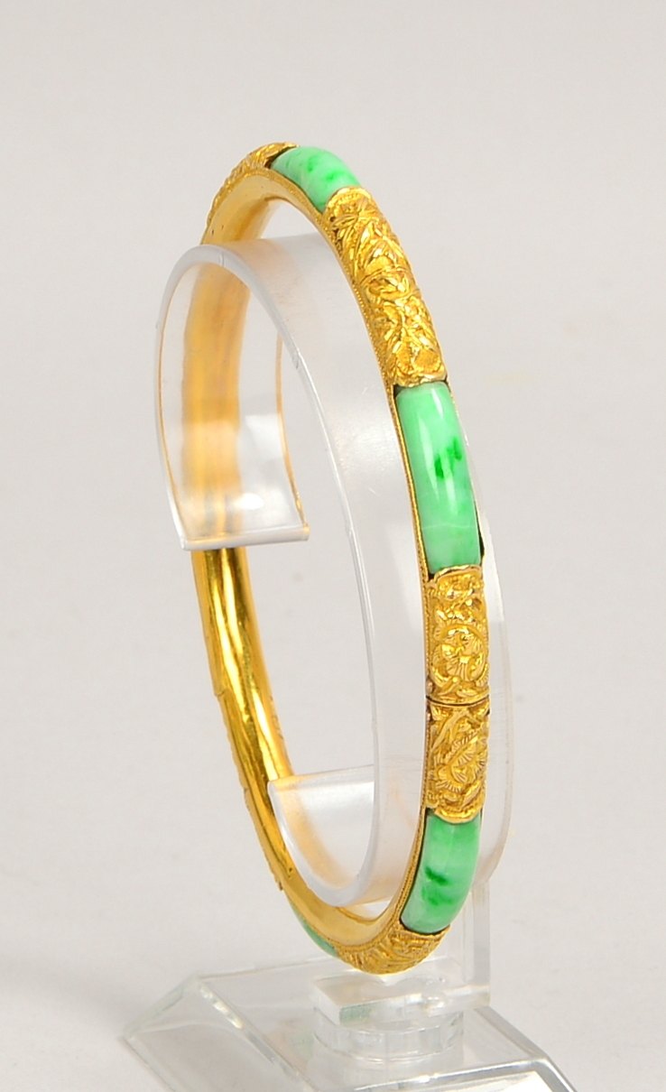 Armreif (China), 750 GG (punz. 18 kt), Jadebesatz und flor. Reliefdekor; Gewicht 26 g