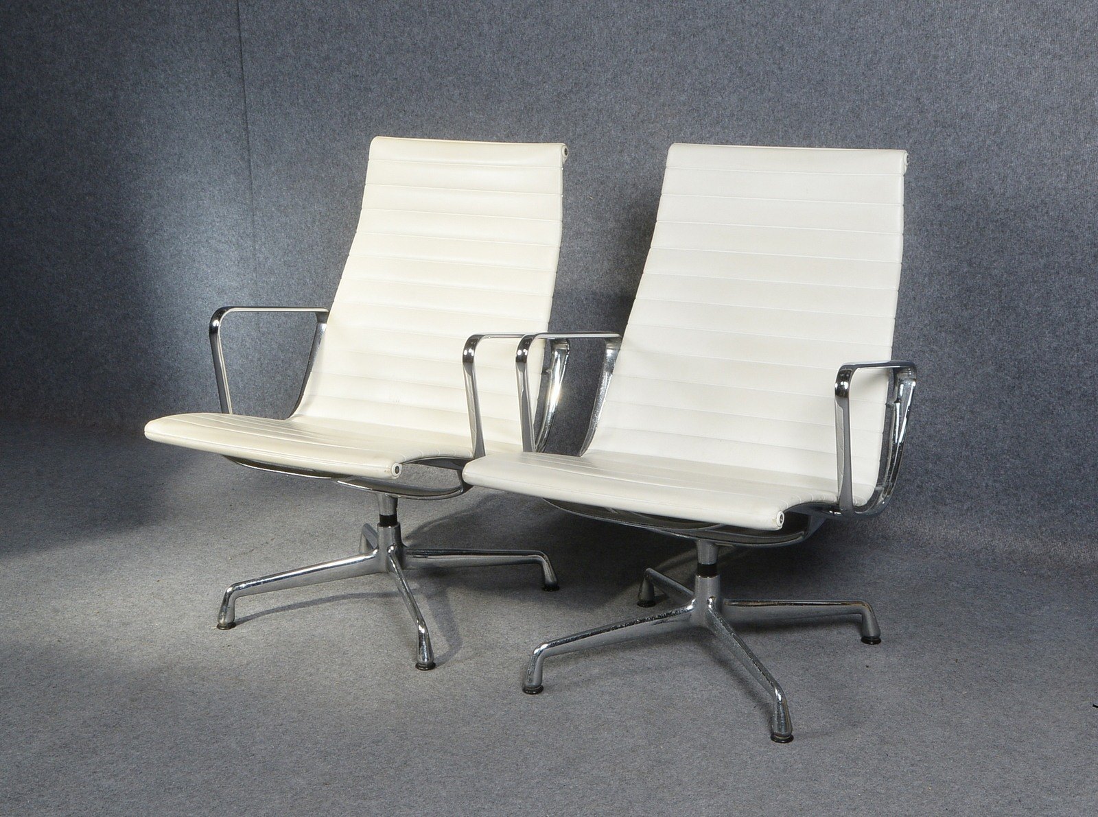 Eames, Paar Stühle, Modell 'EA 115', Aluminium mit weißem Lederbezug, auf Chromfuß; Sitzhöh