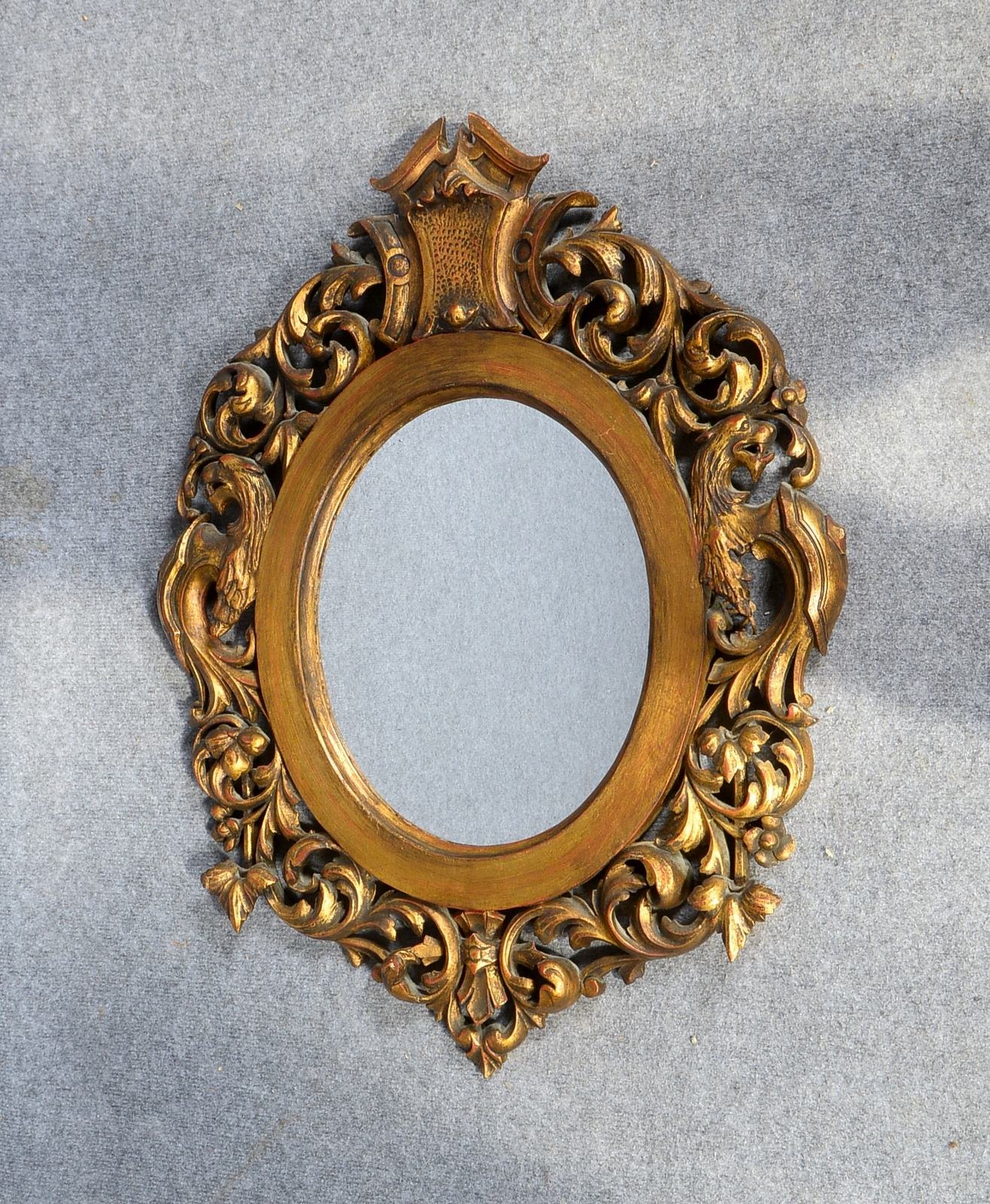 Wandspiegel, ovaler Holzrahmen mit durchbrochenem Schnitzwerk, goldgefasst; Höhe 74,5 cm