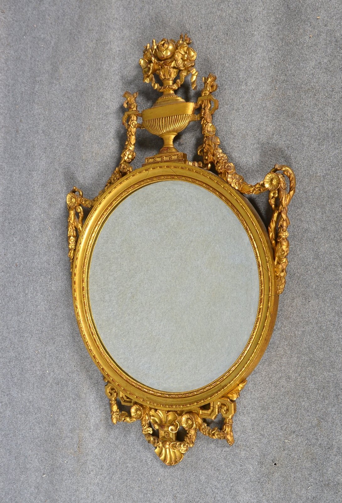 Empire-Wandspiegel, rund, fac. Spiegelglas, holzgeschn./vergoldet; Höhe ca. 120 cm