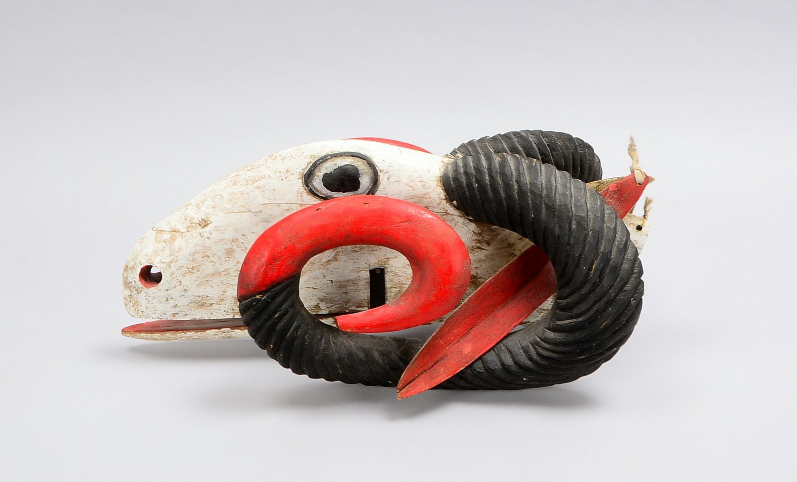 Holzskulptur (Afrika-?), 'Widderkopf', Holz farbig gefasst; Länge 52 cm