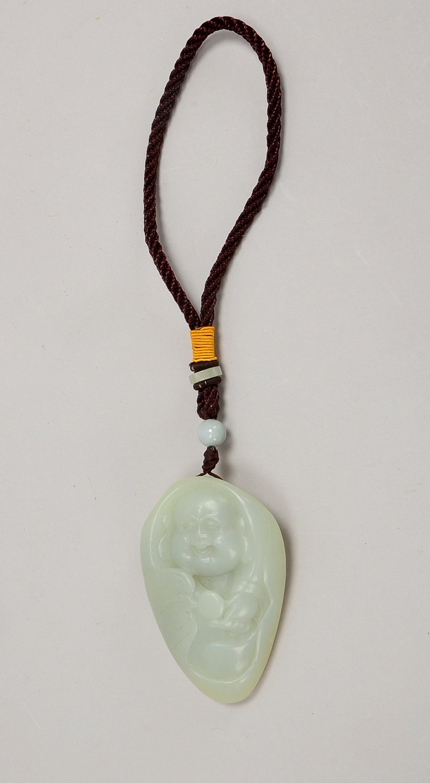 Amulett/Handschmeichler (China), Jade, mit Reliefmtotiv ('Buddha-Darstellung'); Maße 8 x 5 cm