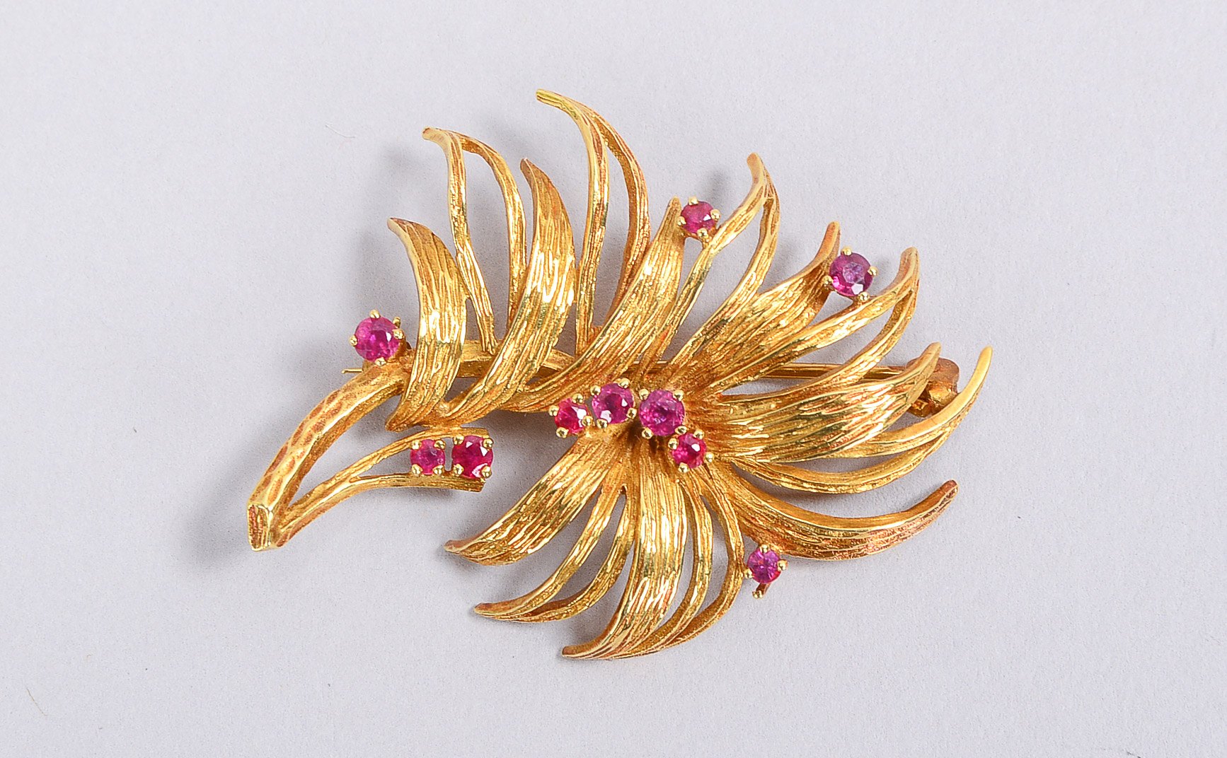 Figürliche Brosche, 585 GG (geprüft), 'Blütenzweig', mit 10-fachem Cabochons; Länge 5 cm, Gewicht 10