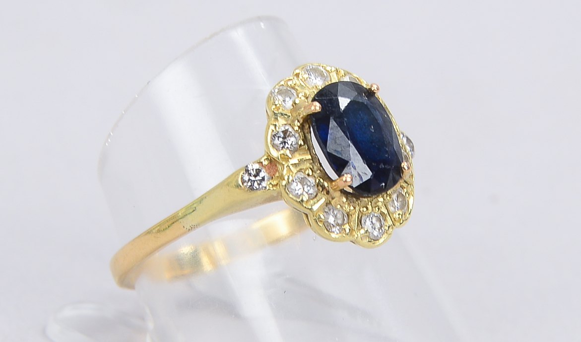 Ring, 585 GG (geprüft), besetzt mit einzelnem Saphir, Stein im Ovalschliff, mit einer Entourage aus