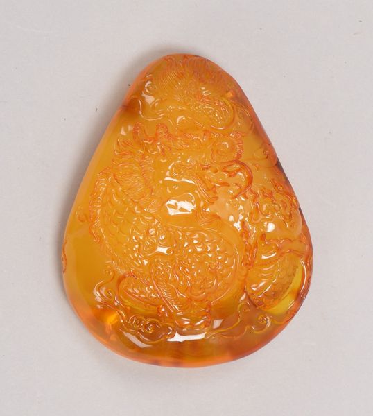 Bernsteinschnitzerei mit Reliefdekor, 'Drache'; Maße 8,7 x 7 x 3 cm, Gewicht 75 g