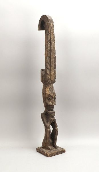 Hölzerne Stele, mit sitzender Figur; Höhe 100 cm (Sockel mit Trocknungsriss)