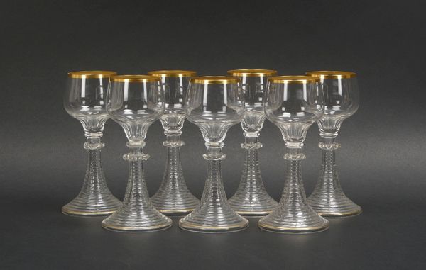 7 Weingläser, Klarglas, Kuppa mit Goldrand, getreppter Fuß; Höhe jew. 16,5 cm