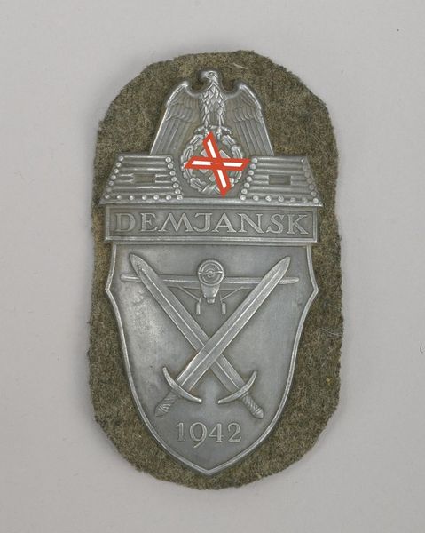 Ärmelschild (II. WK), 'Demjansk 1942', gepr. Blechschild/versilbert, auf Heeresstoff