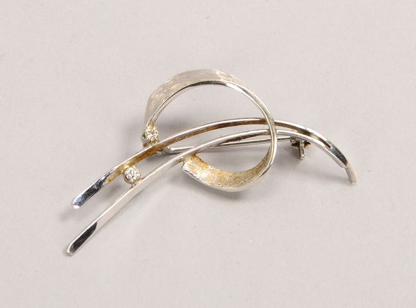 Brosche, 750 WG (gest.), besetzt mit 2x kl. Brill.; Länge 4,5 cm, Gew. 3,20 g