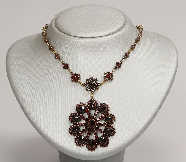 Tombak-Collier mit Granatbesatz, fac. Steine im Rund- und Ovalschliff, mit gr. Rosette