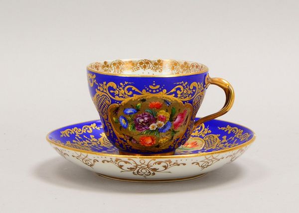 Meissen (I. Wahl), Sammeltasse mit UT, rocailliertes flor. Dekor auf Blau, goldstaff.