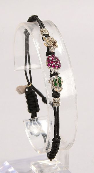 Pippo Perez-Armband, 3x Charms, 750 WG (gest.), jeweils mit Steinbes., an Kordelarmb.