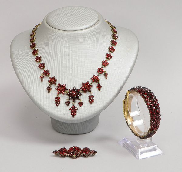 Schmuckset mit Granatbesatz: Collier, Länge 41 cm; Armreif, Ø 5 x 5,5 cm; und Brosche