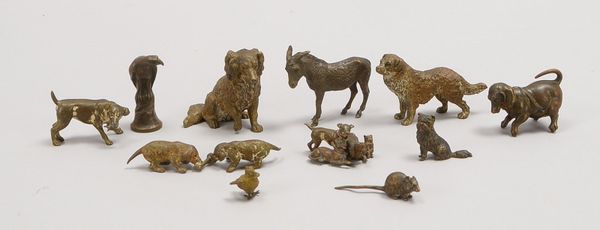 12 Kleinbronzen: 8x Hundefiguren - teils mit Beute, sowie Esel, Falke, Küken, Ratte