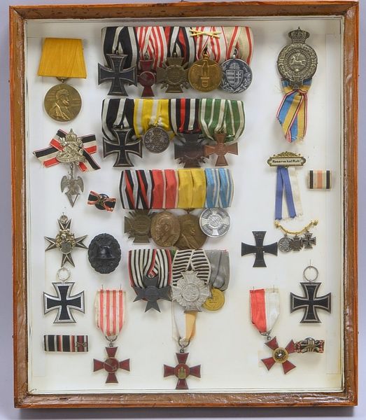 Orden/Abzeichen-Slg., versch. Zeiten und Ausf., in Glasvitrine; Höhe 42 cm