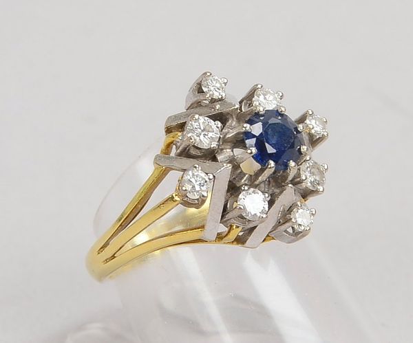 Ring, 585 GG/Wg (gestempelt), besetzt mit einzelnem Saphir, Stein mit einer Entourage aus Diamanten;