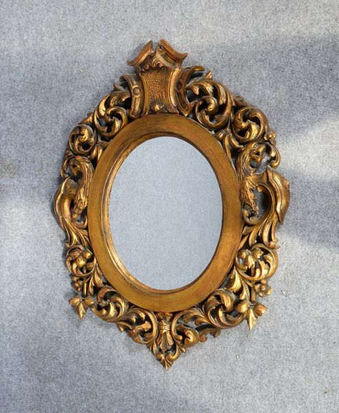 Wandspiegel, ovaler Holzrahmen mit durchbrochenem Schnitzwerk, goldgefasst; Höhe 74,5 cm